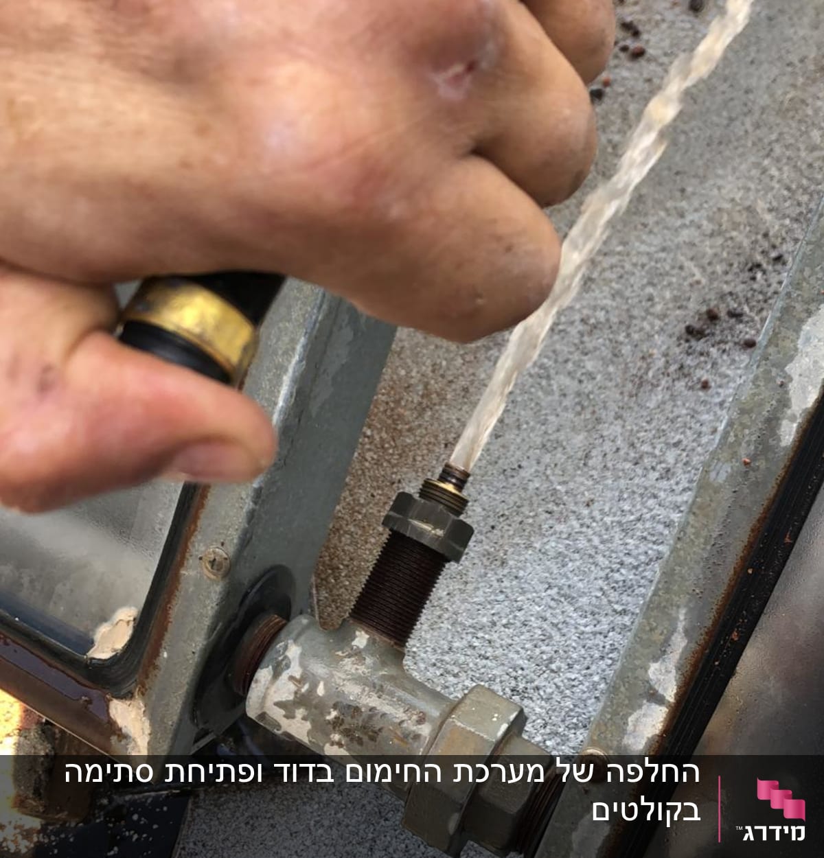 יד מחזיקה צינור מים ליד דוד שמש